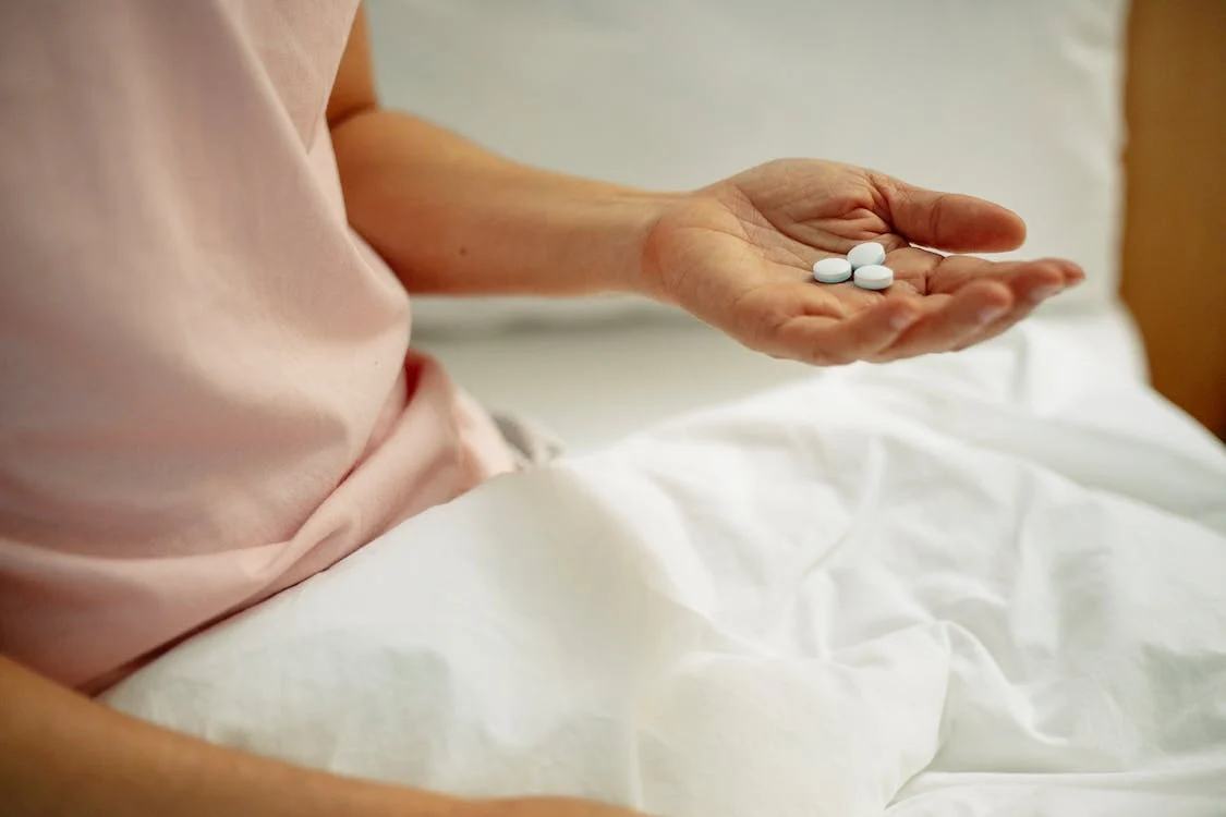 woman in bed holding pills sotagliflozin antibiotics and diabetes