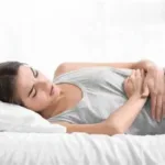 woman lying with hands on tummy because of pain glp 1 gastric emptying Volanesorsen (Waylivra) for Hypertriglyceridemia-Induced Acute Pancreatitis