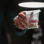 a packet of pills drugs held in an outstretched hand
