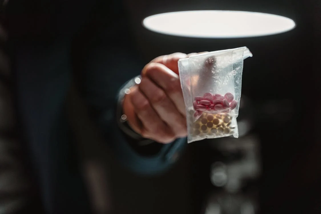 a packet of pills drugs held in an outstretched hand